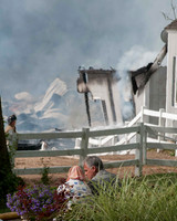 Farm owner looks on as firefighters fight fire