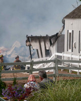 Farm owner looks on as firefighters fight fire